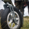 gros plan de roues avec des pneus robustes d'un déambulateur sur un terrain herbeux