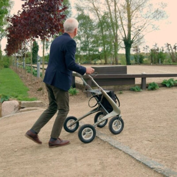 homme poussant le rollator Carbon Overland sur un chemin de terre de chez Acre